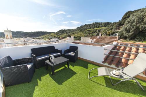 a patio with chairs and tables on a roof at Casa Maria by Sonne Villas in Ferreries