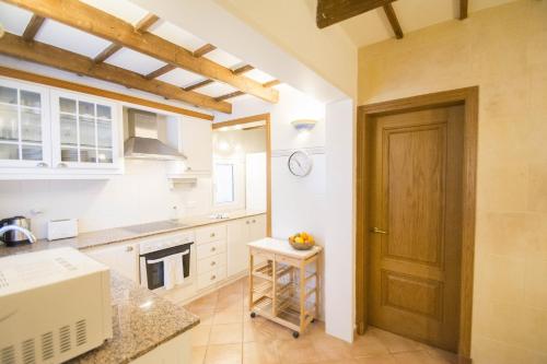 a kitchen with a wooden door and a counter at Casa Maria by Sonne Villas in Ferreries