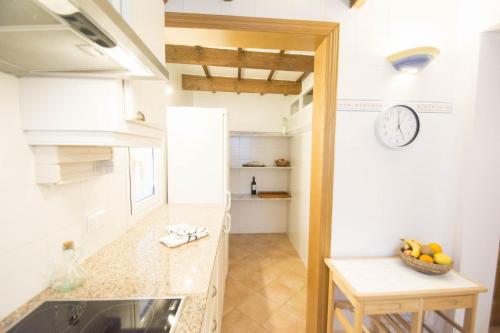 a kitchen with a counter and a clock on the wall at Casa Maria by Sonne Villas in Ferreries