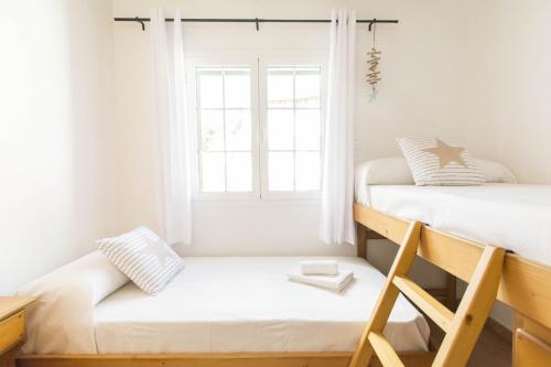 a bedroom with two bunk beds and a window at Casa Maria by Sonne Villas in Ferreries
