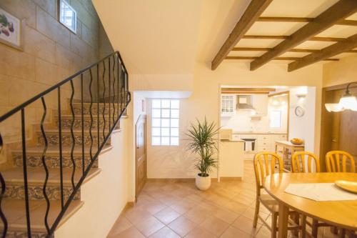 a kitchen and a dining room with a spiral staircase at Casa Maria by Sonne Villas in Ferreries