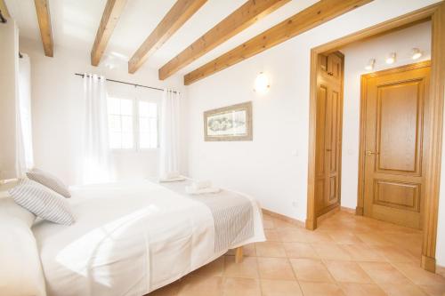 a white bedroom with a bed and a window at Casa Maria by Sonne Villas in Ferreries