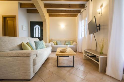 a living room with a couch and a tv at Casa Maria by Sonne Villas in Ferreries