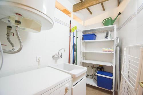 a small white bathroom with a sink and shelves at Casa Maria by Sonne Villas in Ferreries