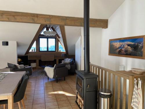 un salon avec un poêle à bois dans une pièce dans l'établissement les 7 laux immobilier chalet B, à Prapoutel