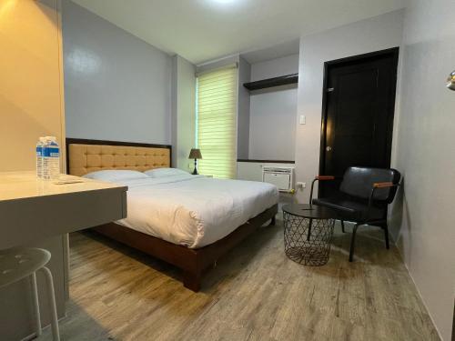 sypialnia z łóżkiem, biurkiem i krzesłem w obiekcie J Spazio Apartelle and Cafe w mieście Baranghauon
