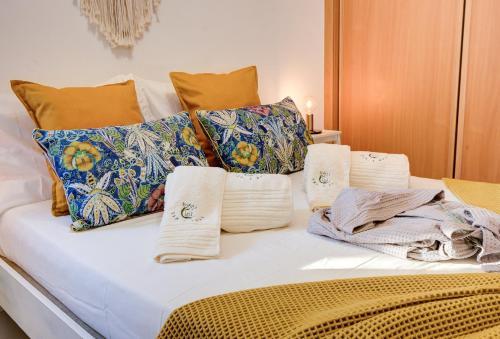 a bed with colorful pillows and towels on it at Casa da Avó Ti in Azoia