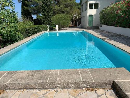 una piscina con acqua blu in un cortile di VIlla Saint Clair avec piscine a Sète