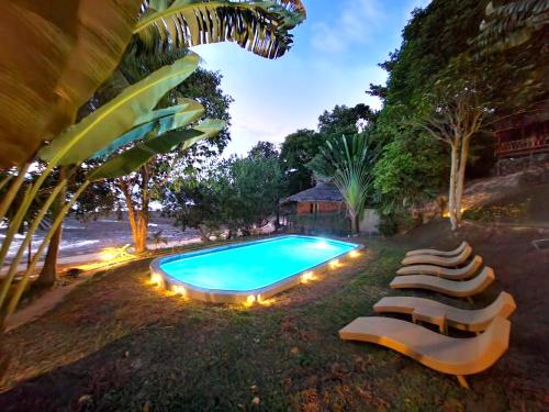 a swimming pool with lounge chairs next to a resort at Banyan Bay Villas in Ko Jum