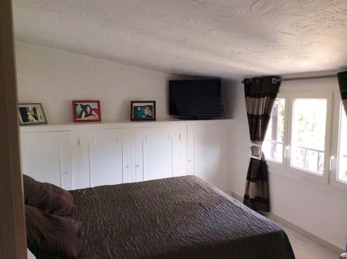 une chambre avec un lit et une télévision à écran plat dans l'établissement Villa élégante avec piscine privée à Le Cannet, au Cannet