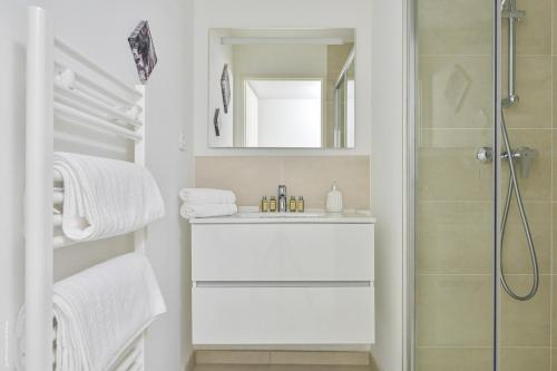 a white bathroom with a shower and a sink at T2 NEUF A4 RDJ-PISCINE–ACCÈS DIRECT PLAGES ET CENTRE VILLAGE– in Saint-Cyr-sur-Mer