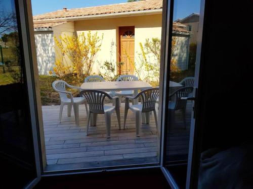 eine Terrasse mit einem Tisch und Stühlen auf einer Veranda in der Unterkunft Maison d'une chambre avec vue sur le lac piscine partagee et jardin amenage a Hourtin in Hourtin