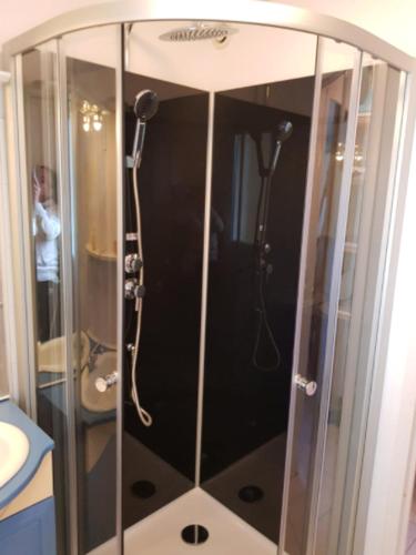 une douche avec une porte vitrée dans une salle de bain dans l'établissement Maison confortable à Hourtin 33 m² avec terrasse, à Hourtin