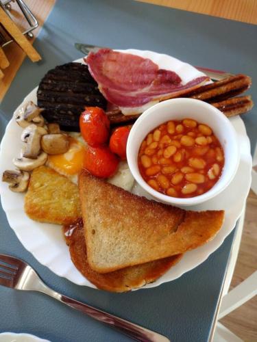 a plate of breakfast food with eggs beans and toast at Seaview B&B in Harwich
