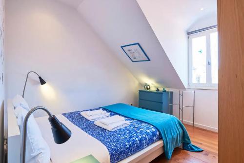 a small bedroom with a bed with a blue blanket at Central & Typical Lisboa by GT House in Lisbon