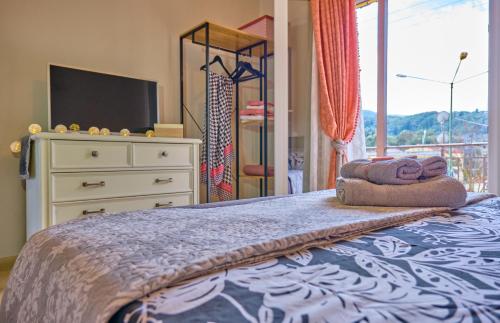 a bedroom with a bed with a dresser and a window at Mandola Studio Perithia Corfu in Perítheia