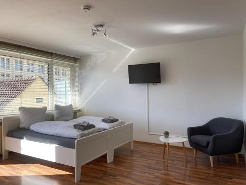 a bedroom with a bed and a chair at Moderne Studios im Herzen von Osnabrueck in Osnabrück