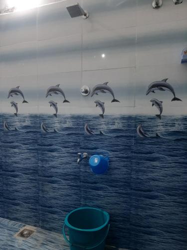 a mural of dolphins on the wall of a bathroom at Padmavathi Home Stay in Chidambaram