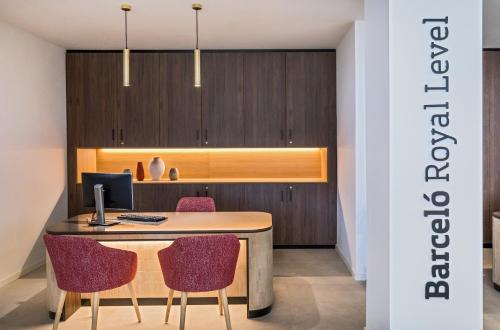 an office with a desk with two chairs and a computer at Barceló Lanzarote Royal Level in Costa Teguise