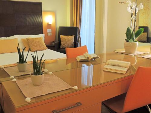 a room with a desk with plants and a bed at Hotel HamilTown in Cattolica