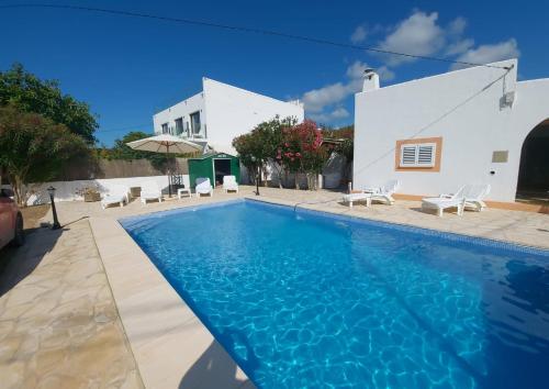 uma piscina em frente a uma casa branca em VILLA CAN PEP RAMON I em Sant Francesc de s'Estany