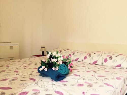 a bouquet of flowers sitting on top of a bed at LES PETITES MAISONS maison orange in Procida