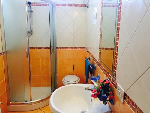 a bathroom with a shower and a sink and a toilet at LES PETITES MAISONS maison orange in Procida