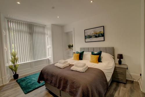 a bedroom with a large bed with towels on it at Bright & Stylish Apartment in Dundee