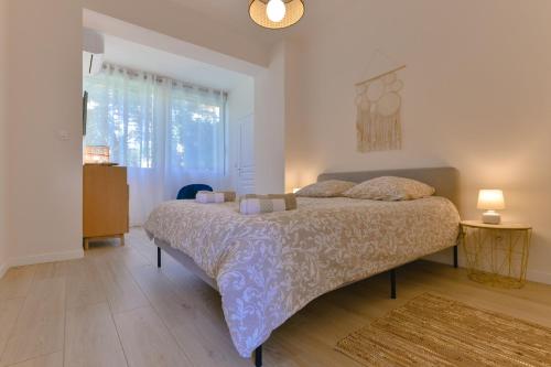une chambre avec un lit et une grande fenêtre dans l'établissement Appartement refait à neuf, proche plage et centre ville- Ajaccio-Parc Berthaut, à Ajaccio
