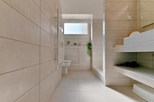 une salle de bain blanche avec toilettes et fenêtre dans l'établissement Appartement refait à neuf, proche plage et centre ville- Ajaccio-Parc Berthaut, à Ajaccio