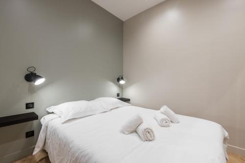 une chambre avec un lit blanc avec des serviettes dessus dans l'établissement Charming 2 Bdr Old Town, à Nice