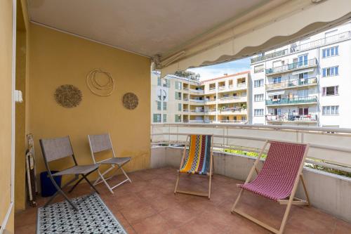 uma varanda com cadeiras e vista para os edifícios em Large 2 Bdr at Nice Port em Nice
