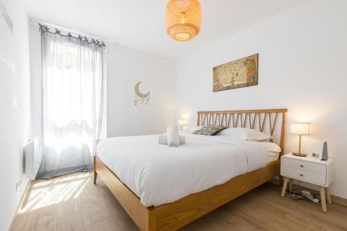 une chambre blanche avec un grand lit et une fenêtre dans l'établissement Large 2 Bdr at Nice Port, à Nice