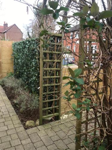 a wooden trellis in a garden next to a fence at The Cabin in Chester