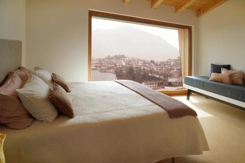 a bedroom with a bed and a large window at Maso al Sole Agriturismo in Civezzano