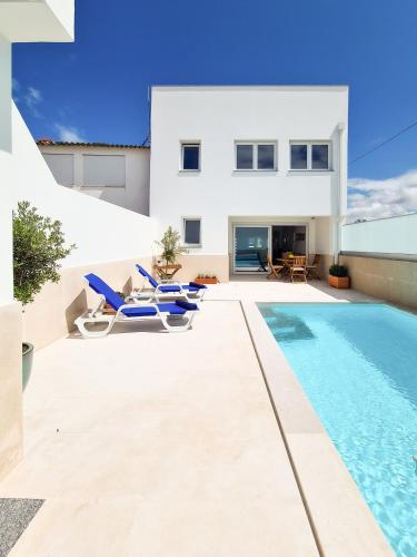 a villa with a swimming pool and a house at Modernes Haus mit spektakulärem Meerblick und Pool in Vale Furado