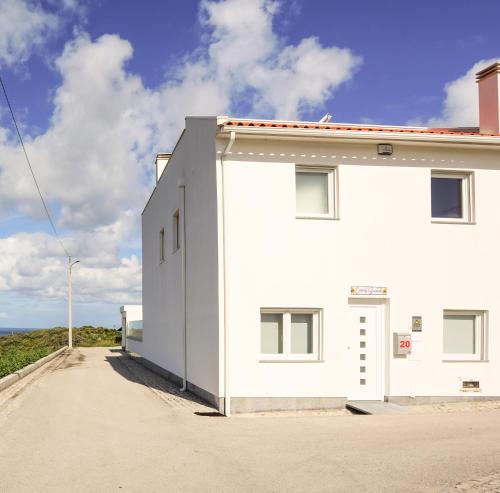 a white building on the side of a road at Modernes Haus mit spektakulärem Meerblick und Pool in Vale Furado