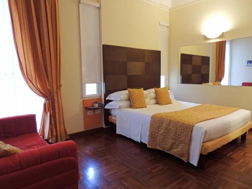 a hotel room with a bed and a couch at Hotel HamilTown in Cattolica