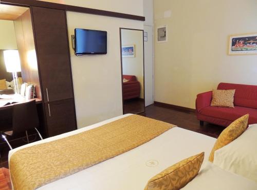 a hotel room with a bed and a red couch at Hotel HamilTown in Cattolica
