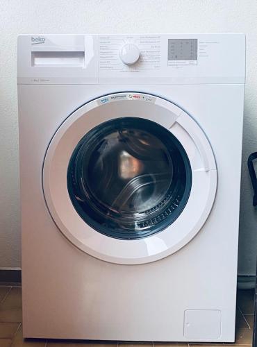 a white washing machine sitting in a room at Regina in Tropea