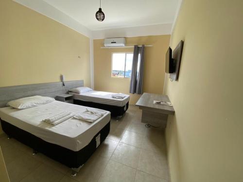 Castanhal的住宿－GRAN PARADA HOTEL，一间医院间,配有两张床和一张书桌