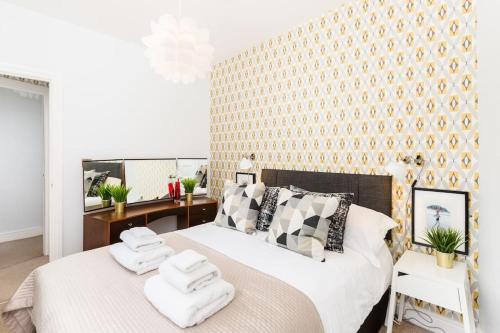 a bedroom with a large bed with towels on it at The Old Morgan Period Town House in Great Malvern