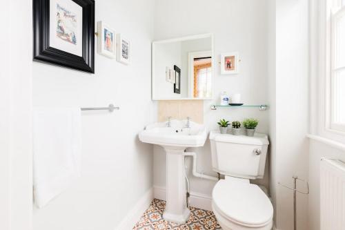 a white bathroom with a toilet and a sink at The Old Morgan Period Town House in Great Malvern