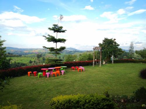 a group of tables and chairs in a field at Phuyafahsai The Resort Khao Kho in Khao Kho