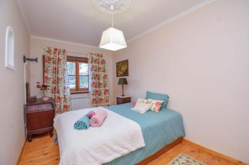 a bedroom with a bed with two stuffed animals on it at Casa das Rosas in Sintra