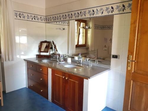 a bathroom with a sink and a large mirror at B&B La Casaccia in Verbania