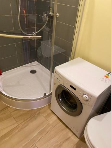 uma máquina de lavar roupa na casa de banho com WC em Mājīgs studio apartaments jūras pilsētā em Ventspils