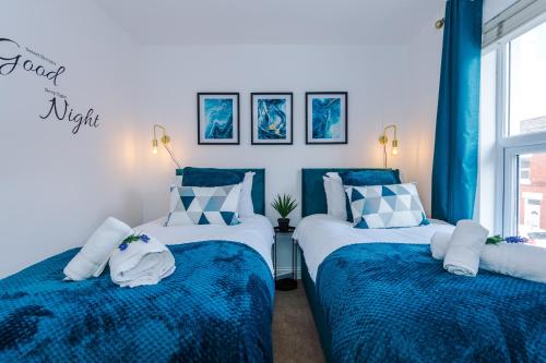 two beds in a room with blue and white at Pristine 2-bed house in Chester by 53 Degrees Property, ideal for Families & Small groups, Great Location - Sleeps 6 in Hough Green
