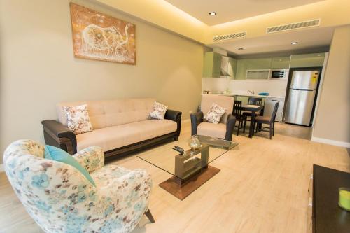 a living room with a couch and chairs and a table at Accra Luxury Apartments @ Pearl in Accra