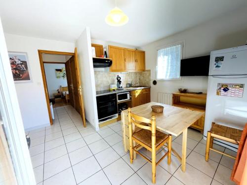 a kitchen with a wooden table and a refrigerator at Appartement lumineux proche plage et parking in Savines